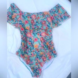 Teal background with colorful floral pattern.